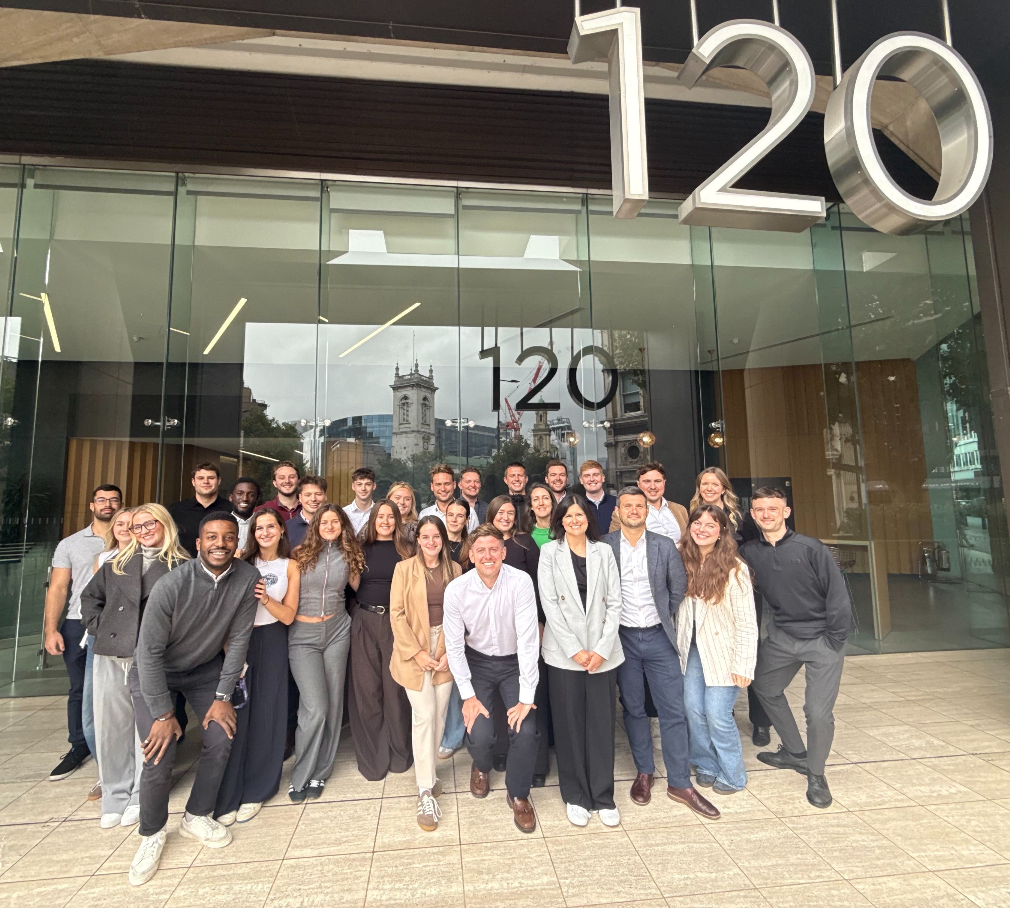 Pareto team members smiling outside their modern office building.